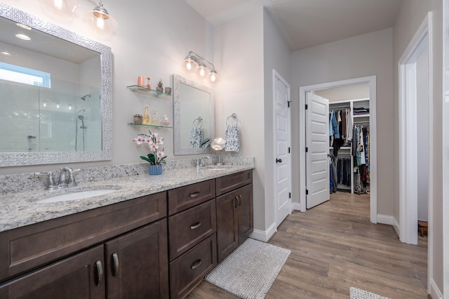 bathroom with a shower, vanity, and hardwood / wood-style flooring