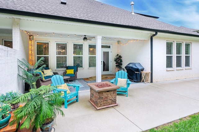 rear view of property featuring ceiling fan, a patio, and an outdoor fire pit