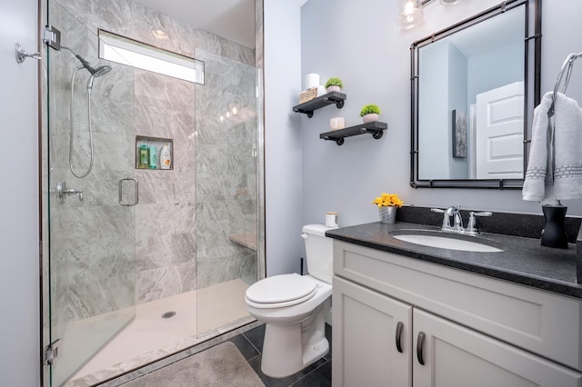 bathroom with tile patterned floors, vanity, an enclosed shower, and toilet