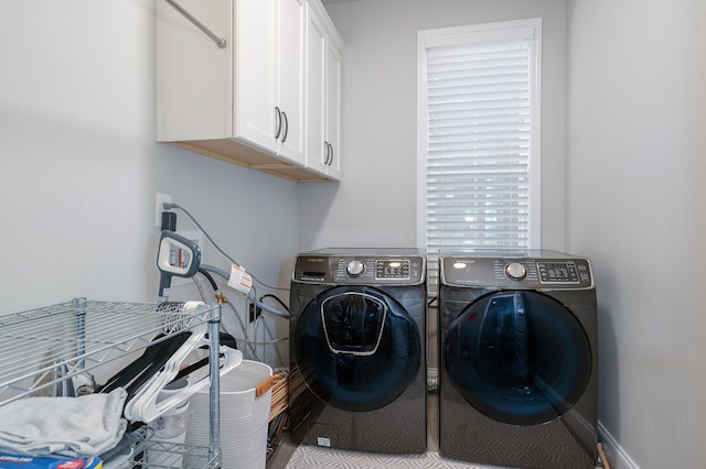 washroom with cabinets and washing machine and dryer