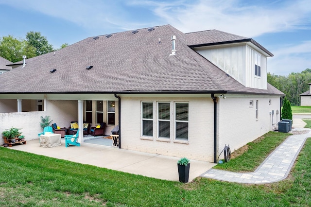 rear view of property with a lawn, a patio area, and central AC unit