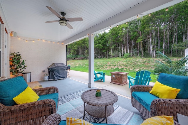 view of patio featuring grilling area, ceiling fan, and an outdoor living space with a fire pit