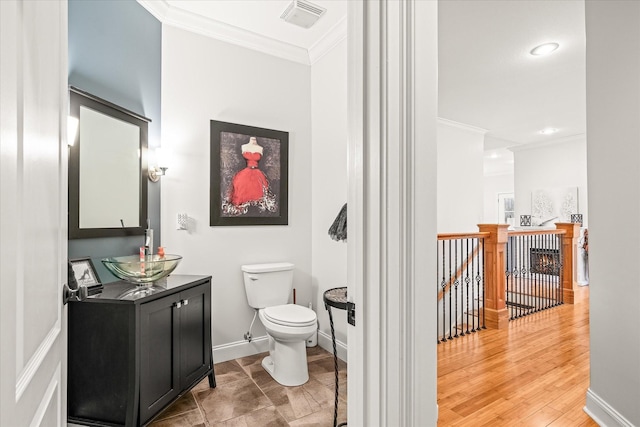 bathroom featuring hardwood / wood-style floors, vanity, toilet, and ornamental molding