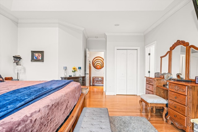 bedroom with light hardwood / wood-style flooring, a closet, and crown molding