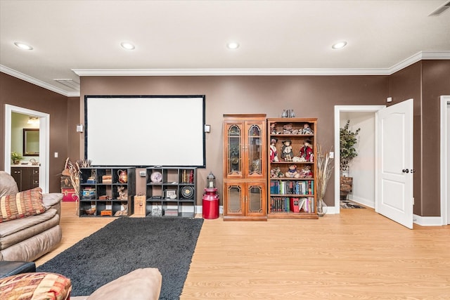 cinema room with wood-type flooring and crown molding