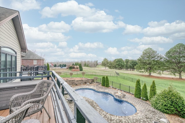 view of pool with a rural view, a yard, and a wooden deck