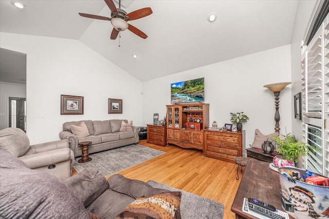 living room with hardwood / wood-style flooring, ceiling fan, and lofted ceiling