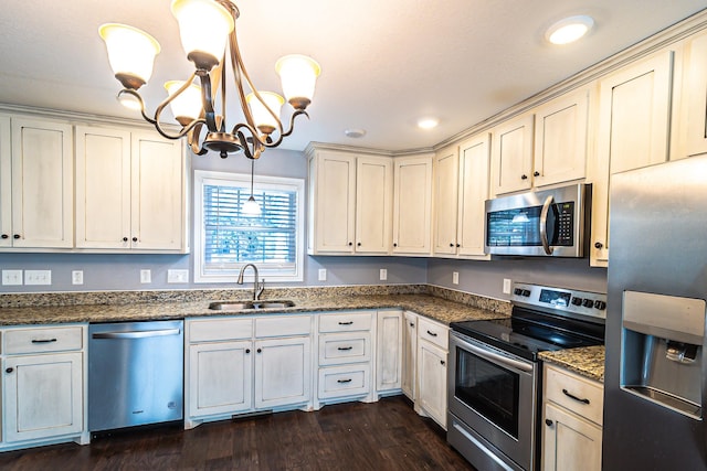 kitchen featuring sink, dark wood-type flooring, an inviting chandelier, pendant lighting, and appliances with stainless steel finishes