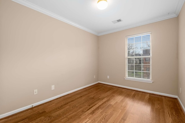 empty room with crown molding and hardwood / wood-style floors