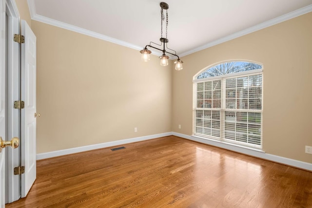 empty room featuring hardwood / wood-style flooring and ornamental molding