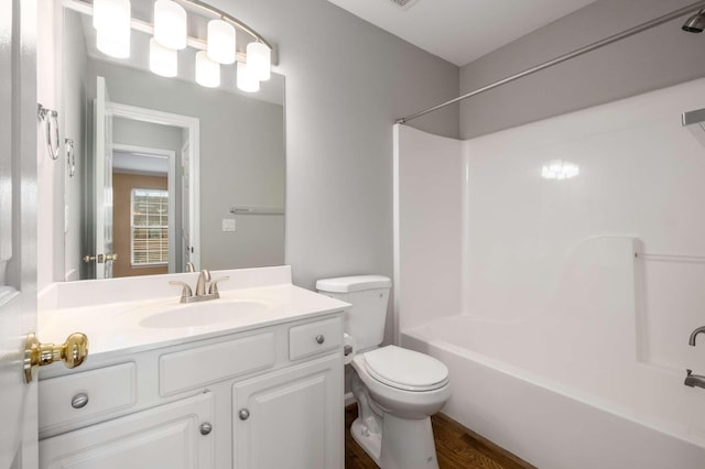 full bathroom with hardwood / wood-style flooring, vanity, shower / bath combination, and toilet