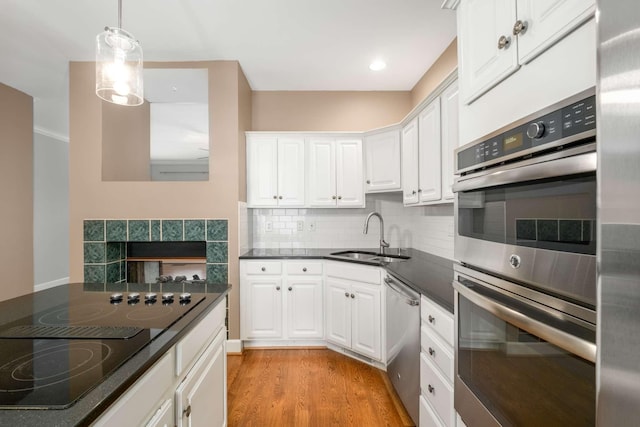 kitchen featuring hanging light fixtures, white cabinetry, sink, and appliances with stainless steel finishes