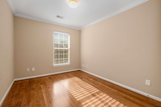 spare room with hardwood / wood-style flooring and crown molding