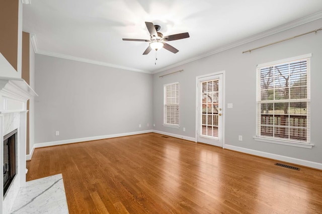 unfurnished living room with a fireplace, hardwood / wood-style floors, ceiling fan, and ornamental molding