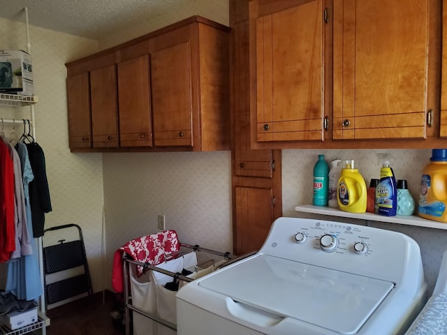 laundry area with cabinets, washer / dryer, and a textured ceiling