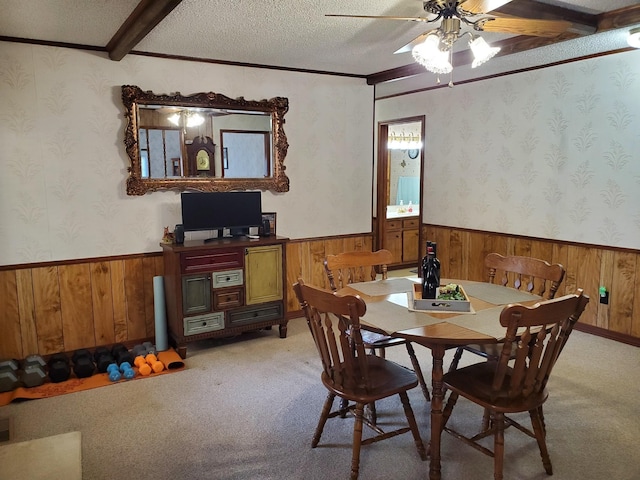 dining room featuring ceiling fan, crown molding, light colored carpet, and a textured ceiling