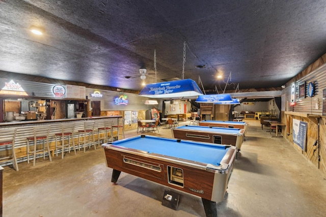 recreation room with wood walls, concrete flooring, and pool table