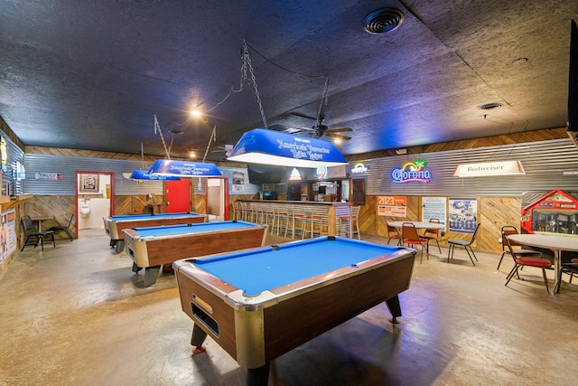 recreation room with wood walls, concrete flooring, and billiards