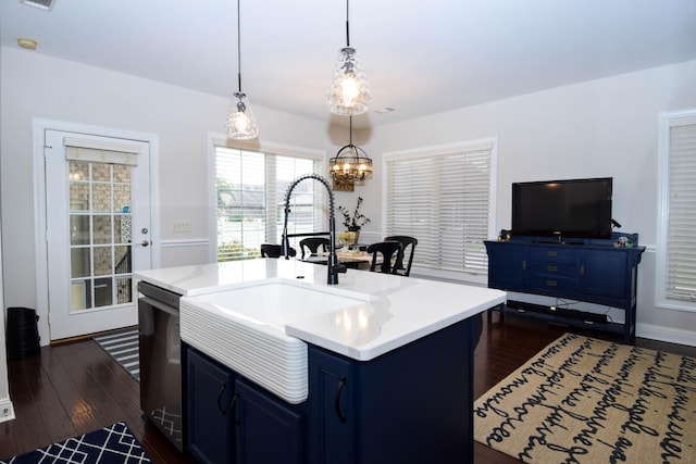 kitchen with sink, hanging light fixtures, stainless steel dishwasher, blue cabinets, and a kitchen island with sink