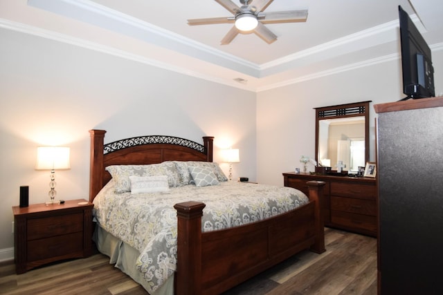 bedroom featuring a tray ceiling, ceiling fan, ornamental molding, and dark hardwood / wood-style floors