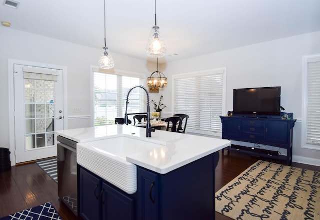 kitchen featuring dark hardwood / wood-style floors, sink, an island with sink, and hanging light fixtures