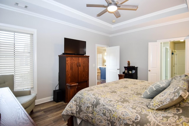 bedroom with a tray ceiling, ceiling fan, dark wood-type flooring, and ornamental molding