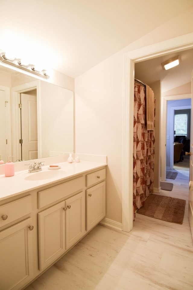 bathroom with a shower with curtain, vanity, and lofted ceiling