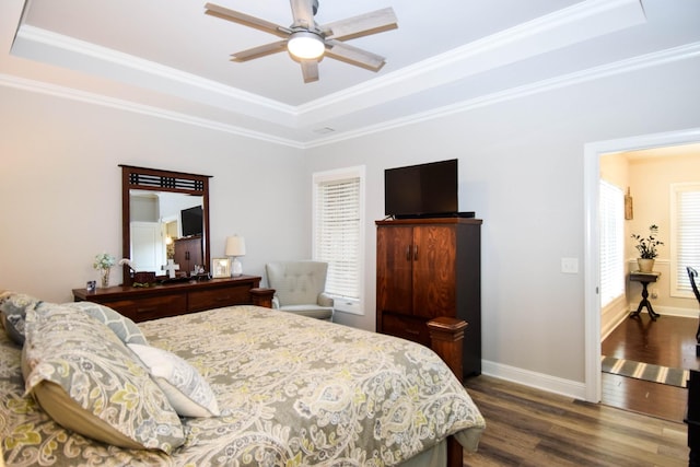 bedroom with a raised ceiling, ceiling fan, crown molding, and dark wood-type flooring