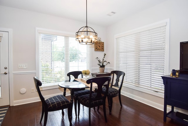 dining area with a notable chandelier and dark hardwood / wood-style floors