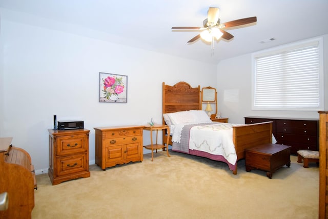 bedroom with ceiling fan and light carpet