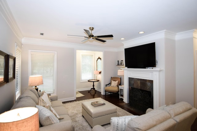 living room with dark hardwood / wood-style floors, ceiling fan, ornamental molding, and a tile fireplace