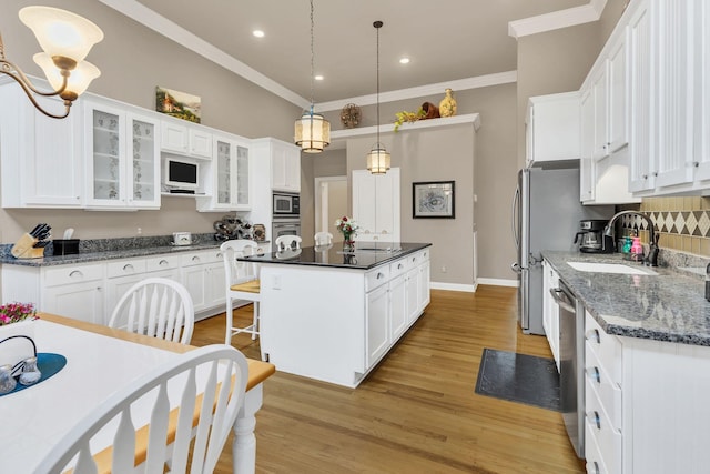 kitchen featuring white cabinets, a center island, and sink