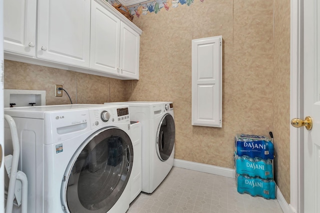 laundry room featuring cabinets, light tile patterned floors, and washing machine and clothes dryer