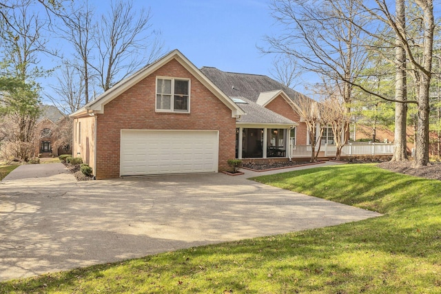 view of front of home featuring a sunroom, a garage, and a front yard