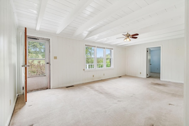 carpeted empty room with beam ceiling, ceiling fan, and a healthy amount of sunlight