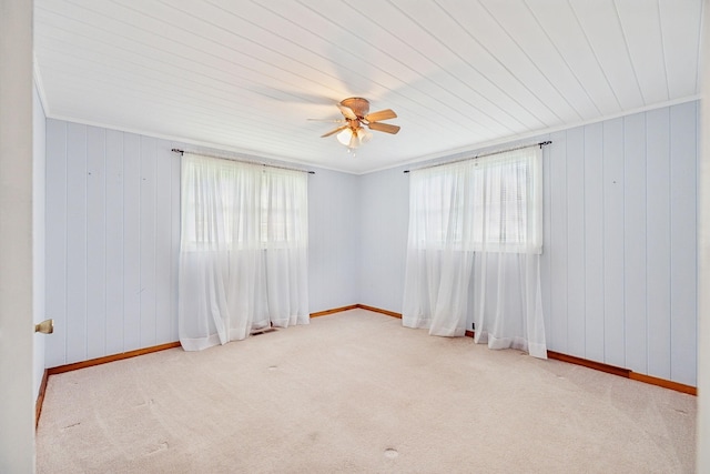 carpeted spare room featuring ceiling fan and crown molding