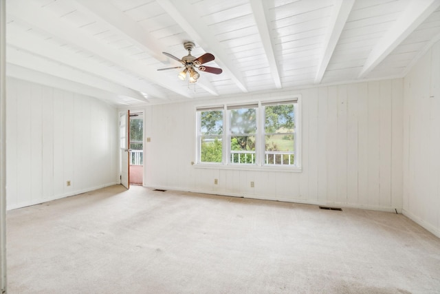 empty room featuring light carpet, beam ceiling, and ceiling fan