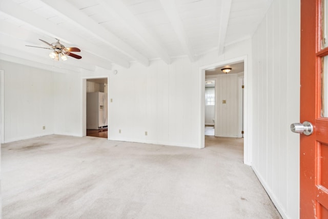 empty room featuring beam ceiling, ceiling fan, and light colored carpet