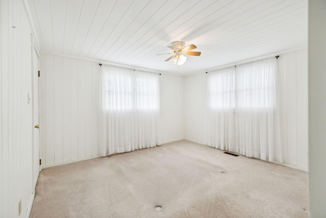 carpeted empty room featuring a wealth of natural light and ceiling fan