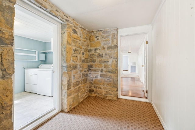 interior space featuring washer and clothes dryer and wooden walls