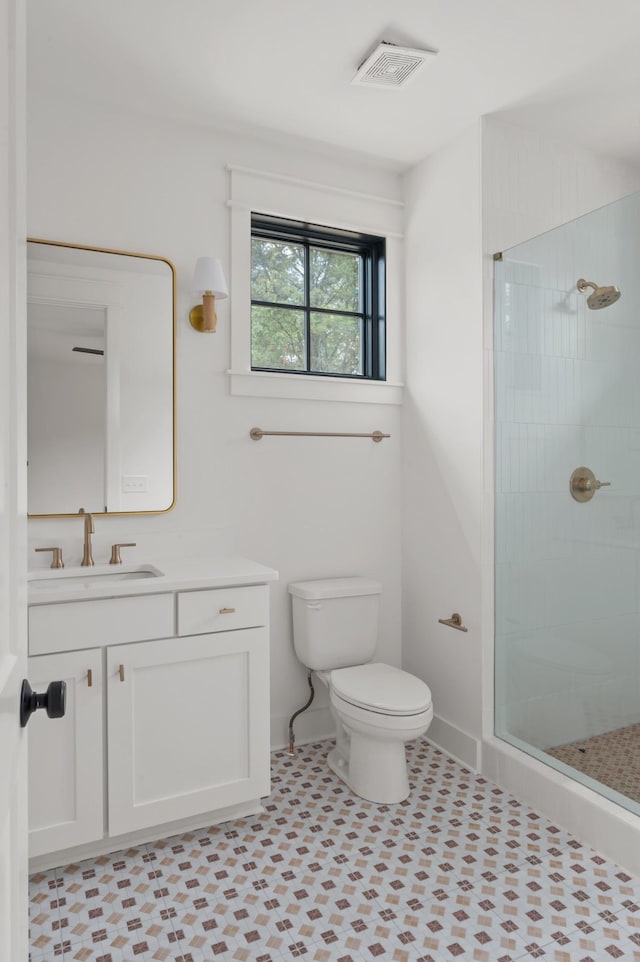 bathroom featuring toilet, an enclosed shower, and vanity