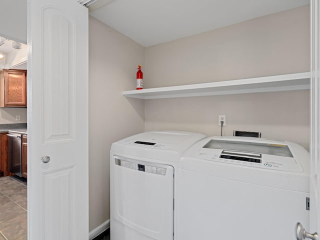 clothes washing area featuring tile patterned flooring and washing machine and clothes dryer