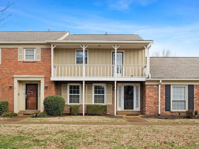 view of front of home featuring a balcony and a front lawn