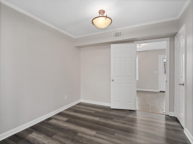 spare room featuring dark hardwood / wood-style floors and ornamental molding