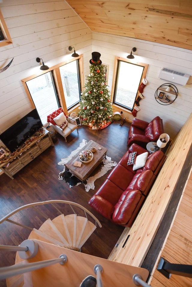 unfurnished living room featuring wood walls, hardwood / wood-style floors, and lofted ceiling