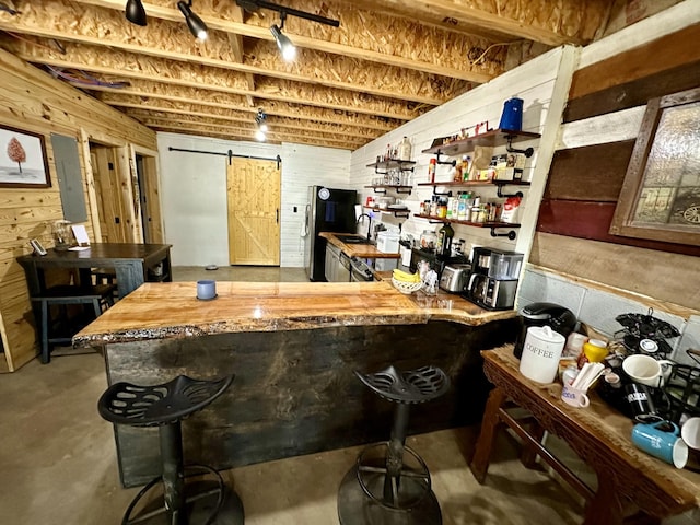 bar featuring a barn door, concrete floors, butcher block counters, and sink