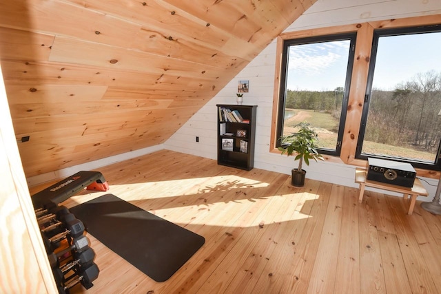 workout area with light wood-type flooring, vaulted ceiling, wooden walls, and wood ceiling