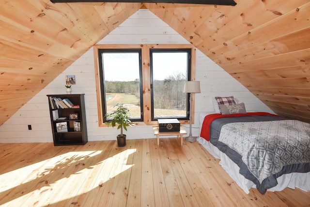 bedroom featuring lofted ceiling, wood walls, wooden ceiling, and light hardwood / wood-style flooring