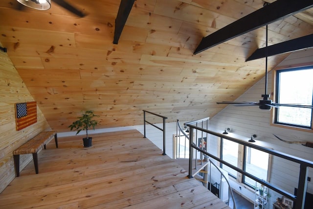 interior space with light wood-type flooring, vaulted ceiling with beams, wooden walls, and wood ceiling