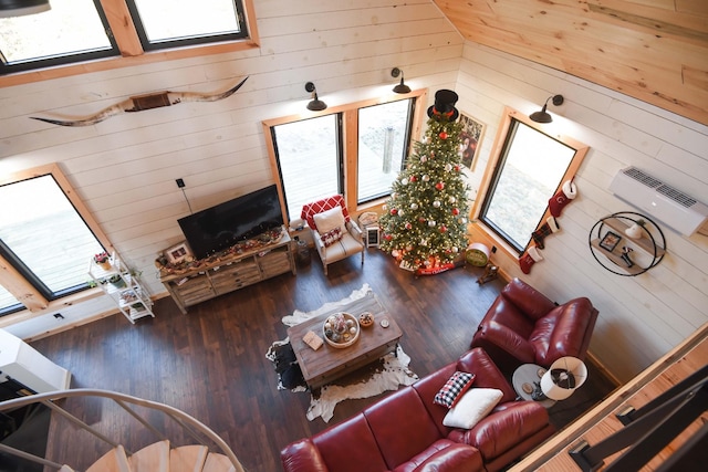 living room with wood walls, wood-type flooring, a wealth of natural light, and vaulted ceiling